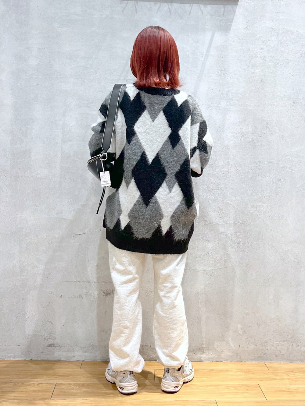 ブラック系のカーディガン/ボレロ、ホワイト系のTシャツ/カットソー、グレー系のスウェットパンツを着用したレディースの冬コーディネートの2枚目の写真