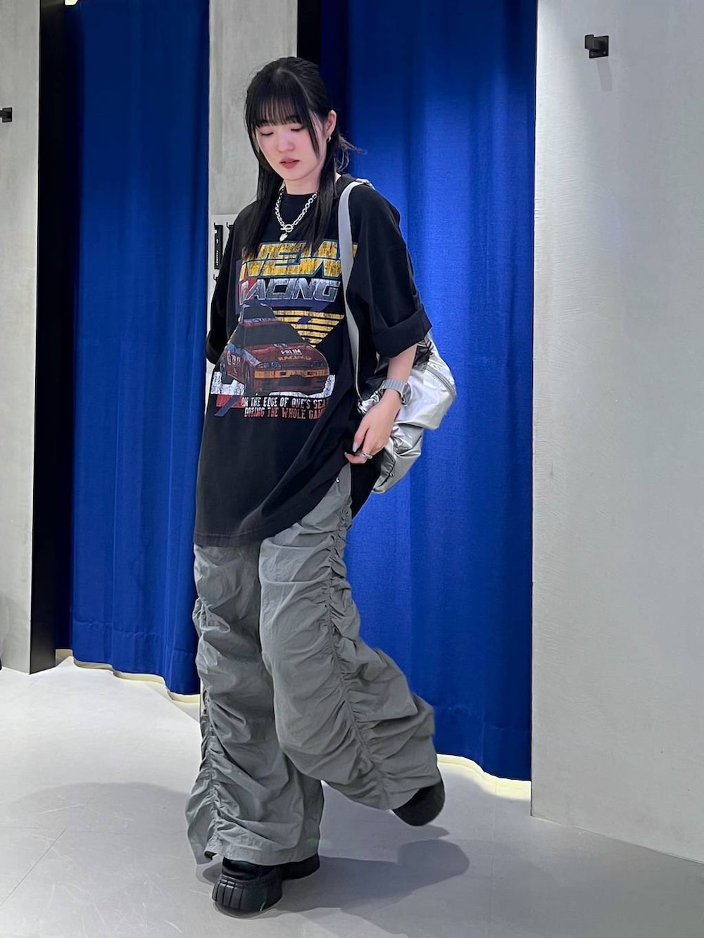 ブラック系のスニーカー、ブラック系のTシャツ/カットソー、シルバー系のショルダーバッグを着用したレディースの春コーディネートの5枚目の写真