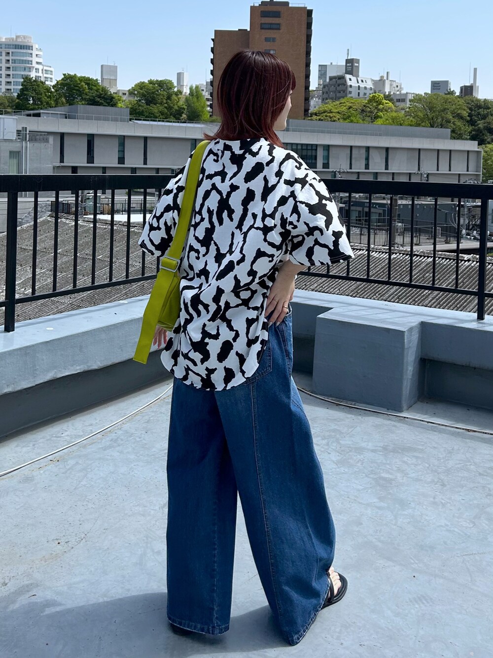 ブルー系のデニムパンツ、ホワイト系のTシャツ/カットソー、イエロー系のショルダーバッグを着用したレディースの春コーディネートの3枚目の写真