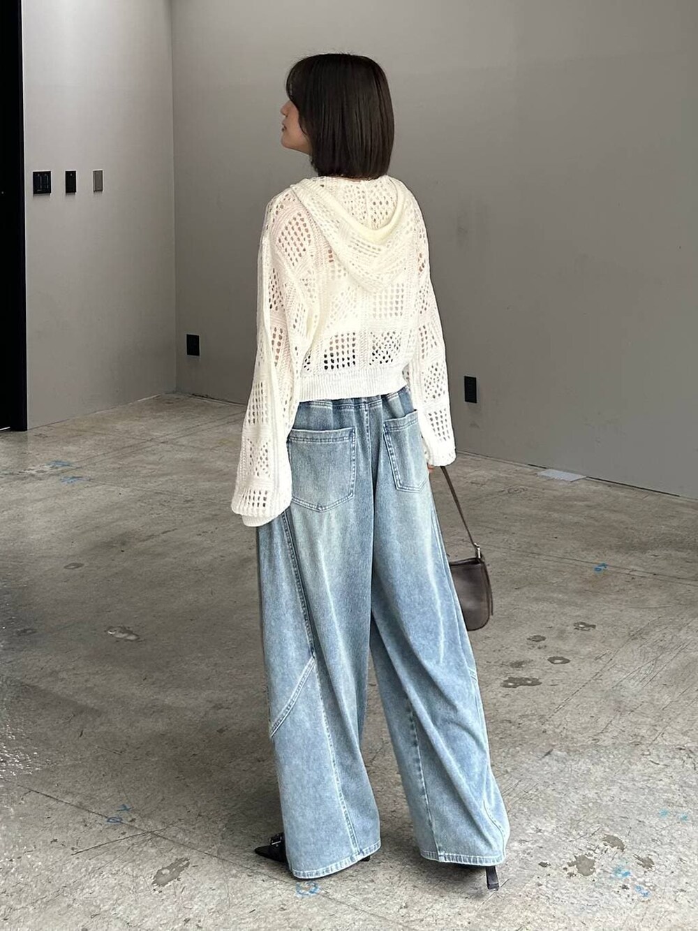 ホワイト系のキャミソール、ブルー系のデニムパンツ、ホワイト系のパーカーを着用したレディースの春コーディネートの5枚目の写真