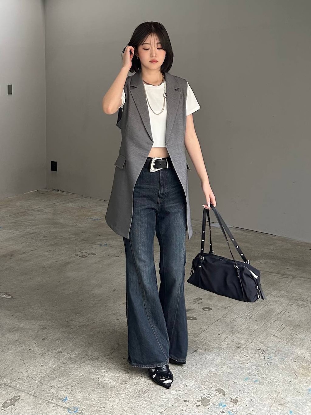 ブルー系のデニムパンツ、ブラック系のサンダル、グレー系のテーラードジャケットを着用したレディースの春コーディネートの2枚目の写真