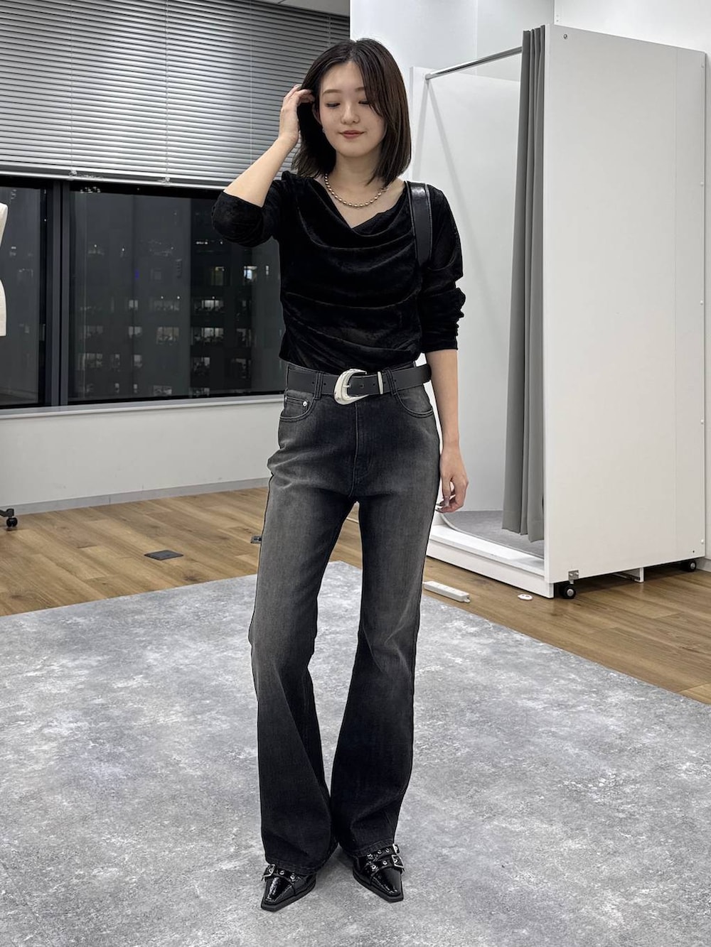 ブラック系のTシャツ/カットソー、ブルー系のデニムパンツ、ブラック系のショルダーバッグを着用したレディースの秋コーディネートの6枚目の写真