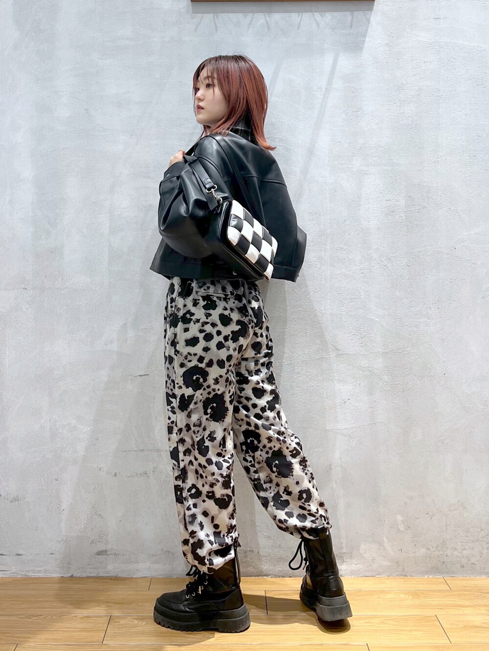 グレー系のその他パンツ、ブラック系のライダースジャケット、ブラック系のブーツを着用したレディースの春コーディネートの2枚目の写真