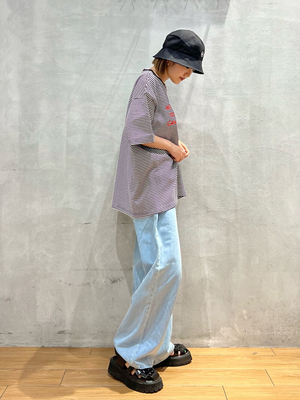 ブラック系のTシャツ/カットソー、ブルー系のデニムパンツ、ブラック系のハットを着用したレディースの夏コーディネートの2枚目の写真