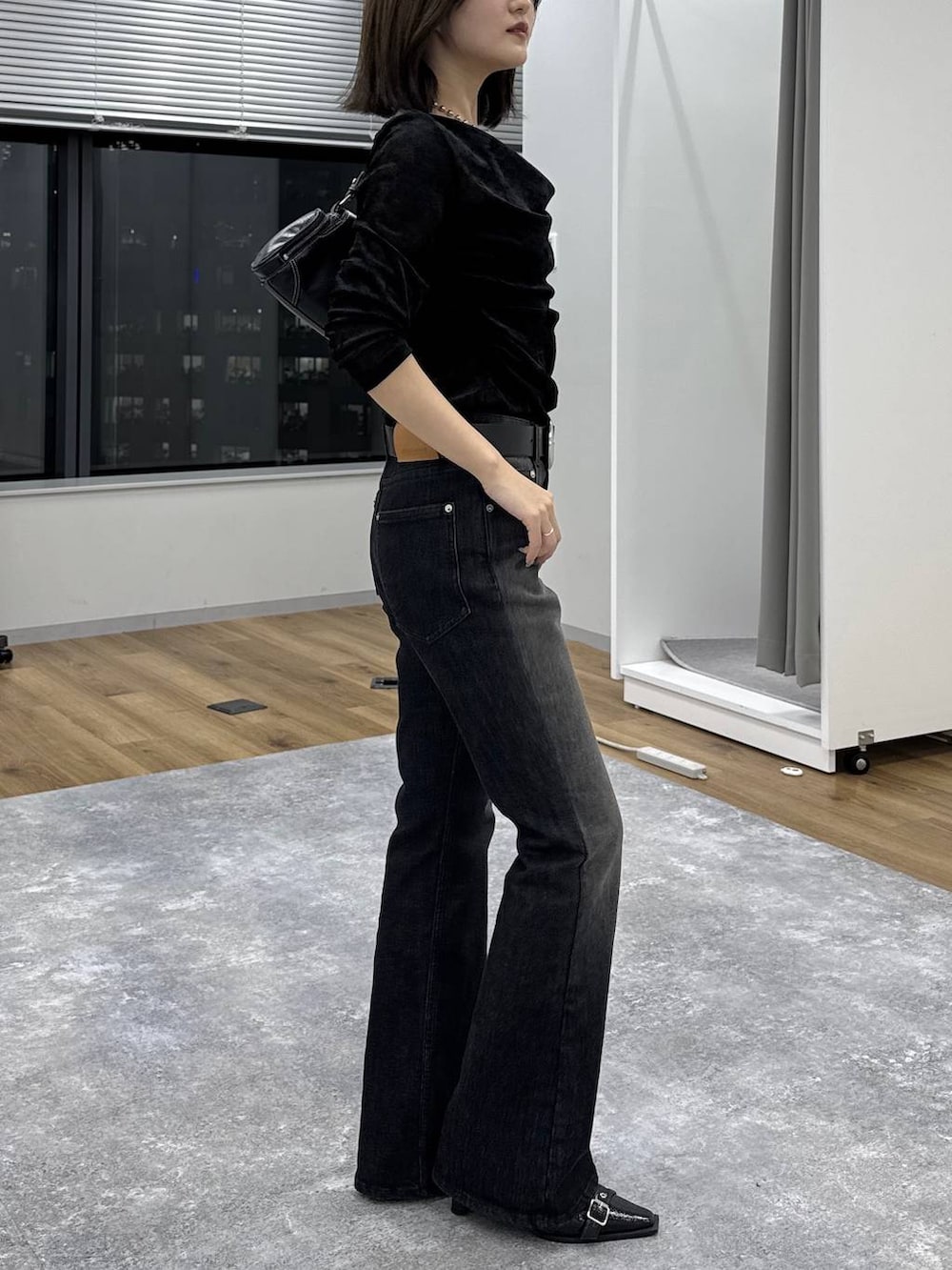 ブラック系のTシャツ/カットソー、ブルー系のデニムパンツ、ブラック系のショルダーバッグを着用したレディースの秋コーディネートの3枚目の写真