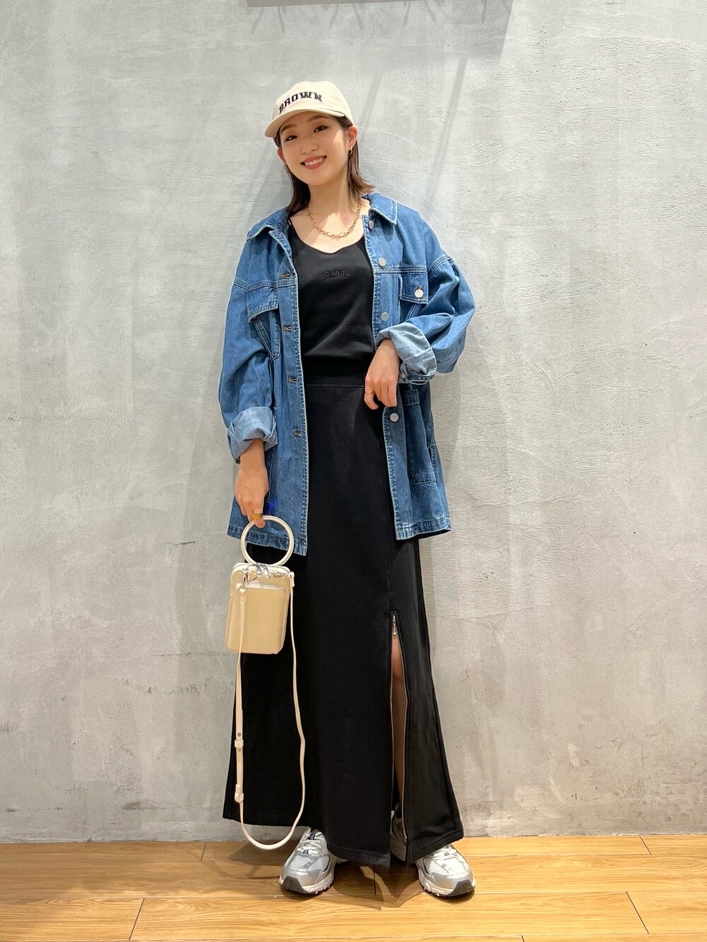 ブルー系のデニムジャケット、ブラック系のキャミソール、ブラック系のスカートを着用したレディースの秋コーディネートの4枚目の写真