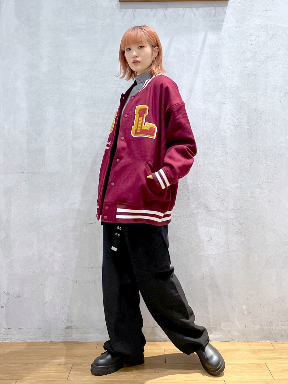 ブラック系のカーゴパンツ、ブラック系のブーツ、レッド系のブルゾンを着用したレディースの秋コーディネートの2枚目の写真