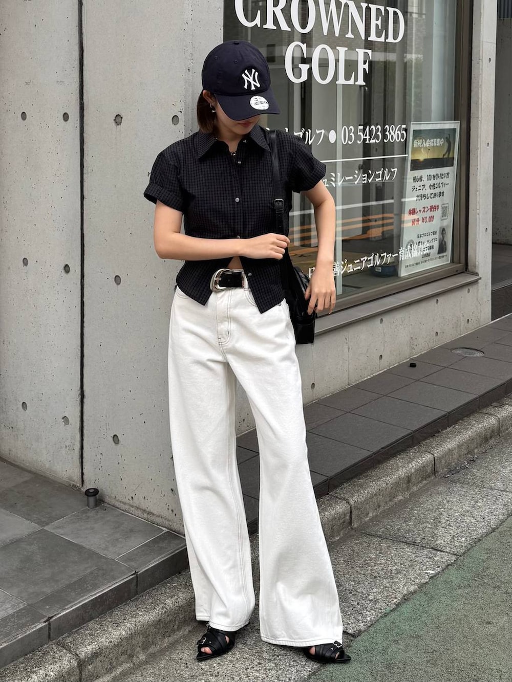 ホワイト系のデニムパンツ、ブラック系のショルダーバッグ、ブラック系のサンダルを着用したレディースの春コーディネートの5枚目の写真