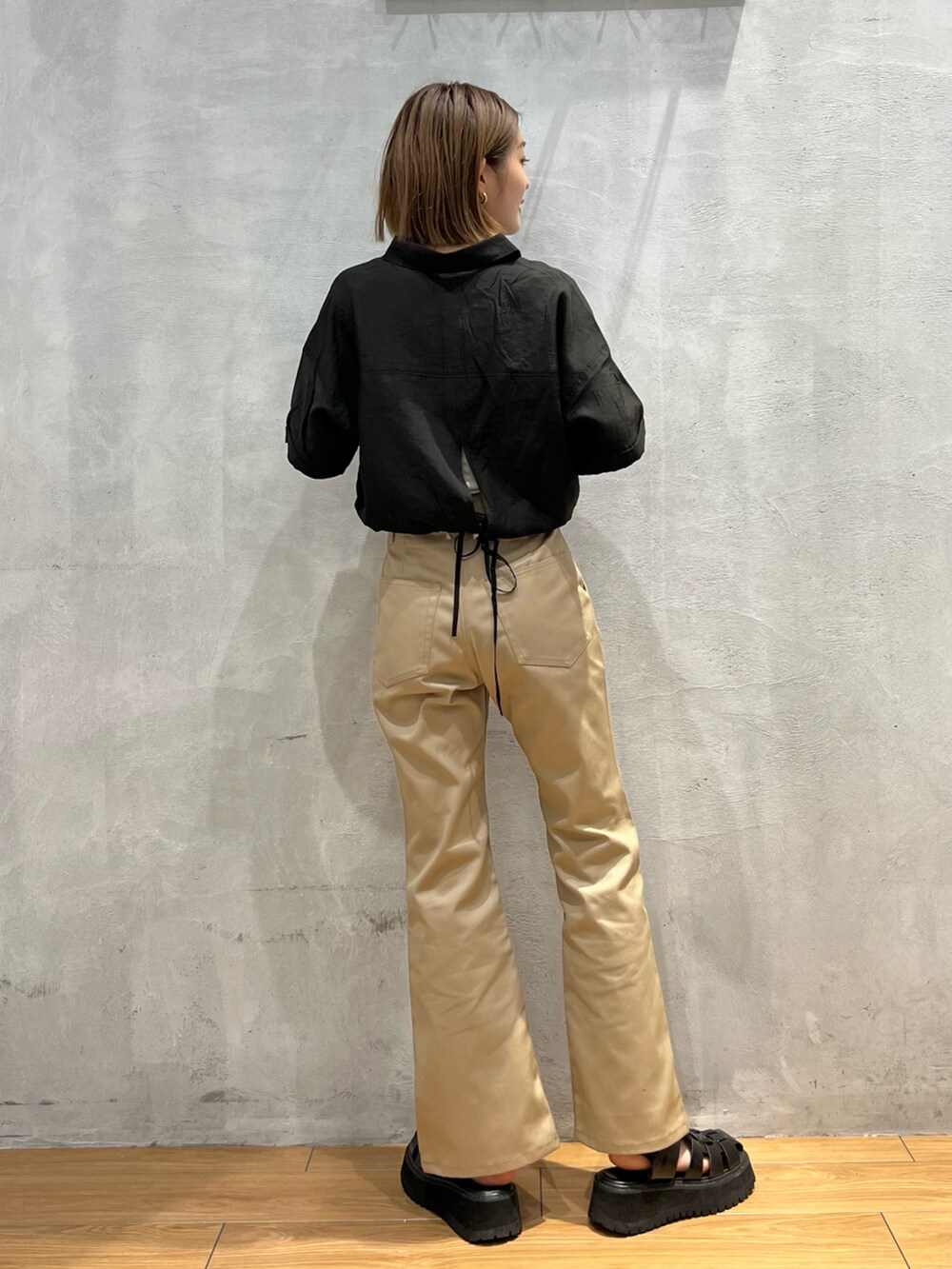 ブラック系のシャツ/ブラウス、ベージュ系のチノパンツ、ブラック系のサンダルを着用したレディースの夏コーディネートの3枚目の写真