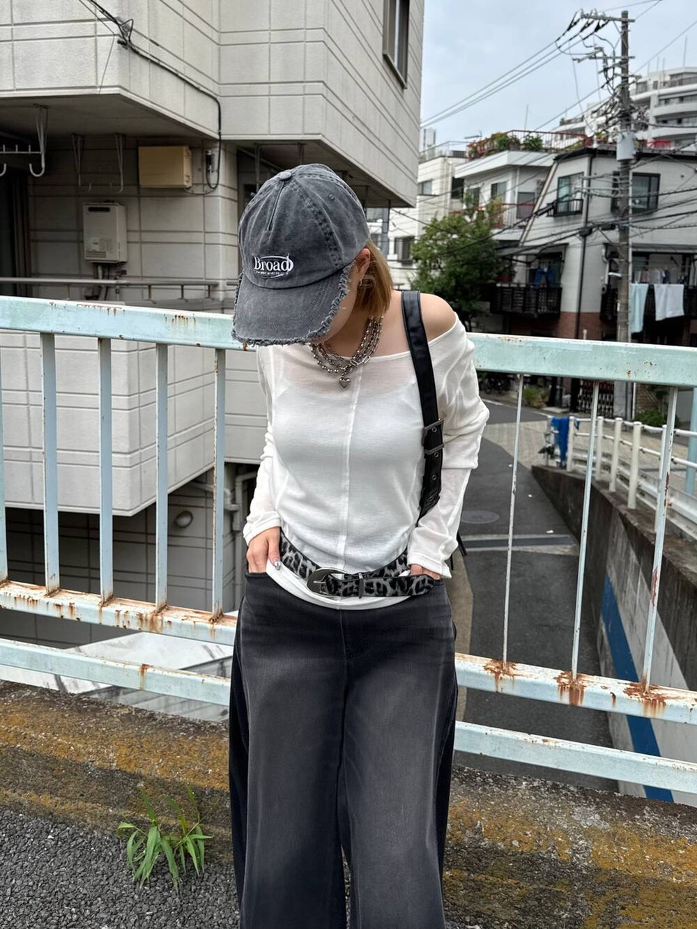 ブラック系のデニムパンツ、ブラック系のショルダーバッグ、ブラック系のキャップを着用したレディースの夏コーディネートの3枚目の写真