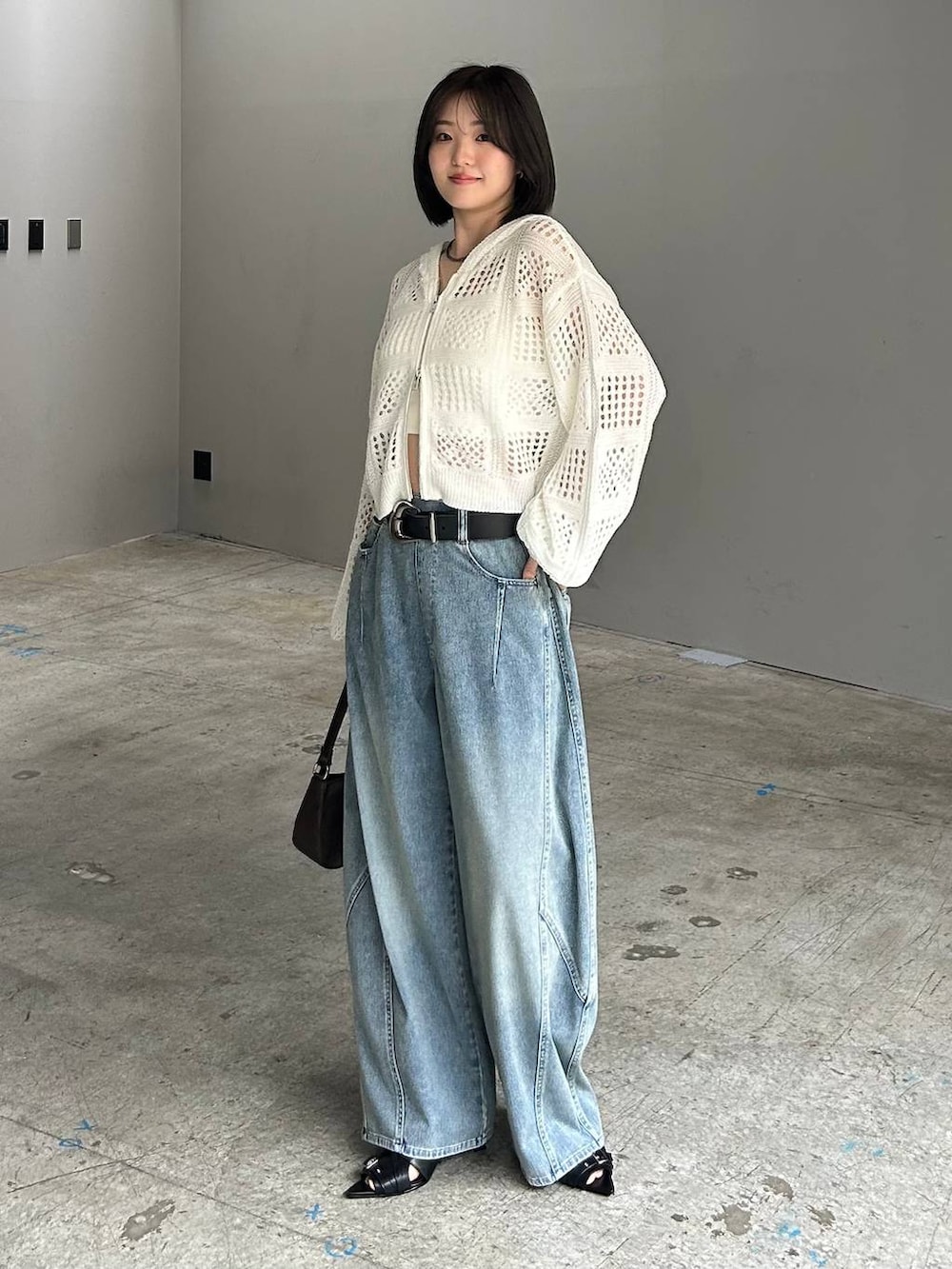 ホワイト系のキャミソール、ブルー系のデニムパンツ、ホワイト系のパーカーを着用したレディースの春コーディネートの2枚目の写真