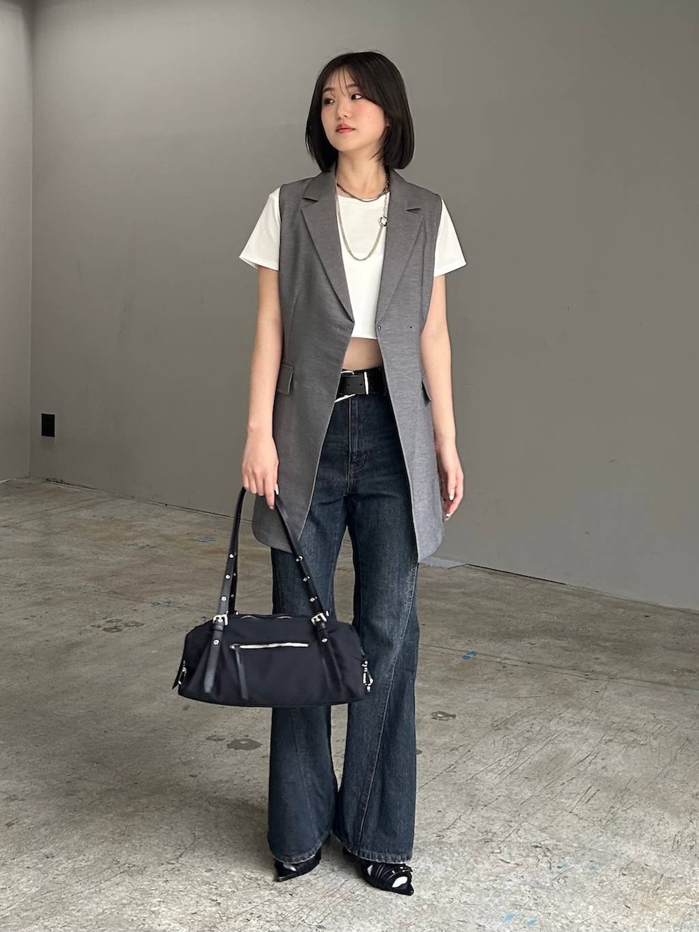 ブルー系のデニムパンツ、ブラック系のサンダル、グレー系のテーラードジャケットを着用したレディースの春コーディネートの7枚目の写真
