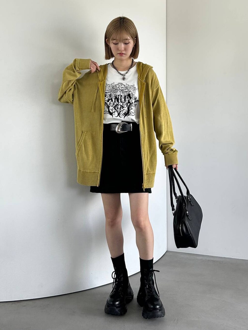 ブラック系のブーツ、ホワイト系のTシャツ/カットソー、イエロー系のパーカーを着用したレディースの夏コーディネートの2枚目の写真