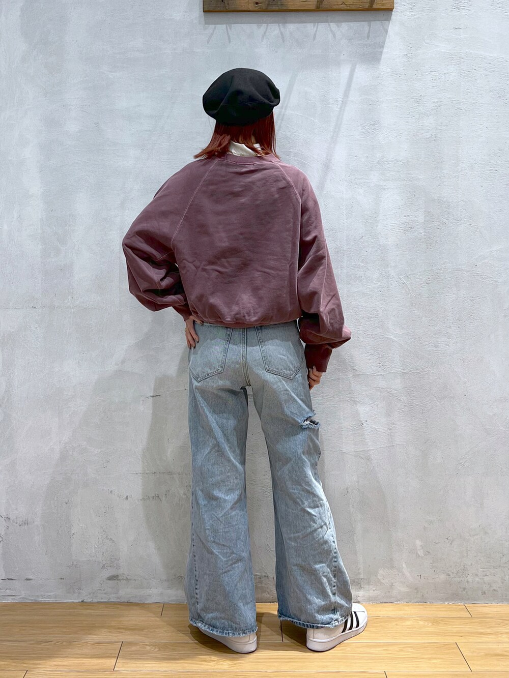 ブルー系のデニムパンツ、レッド系のスウェット、ホワイト系のスニーカーを着用したレディースの冬コーディネートの2枚目の写真