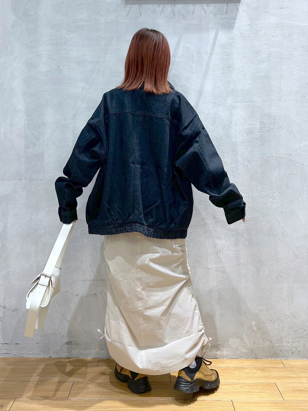 ブルー系のデニムジャケット、グレー系のTシャツ/カットソー、ホワイト系のスカートを着用したレディースの冬コーディネートの2枚目の写真