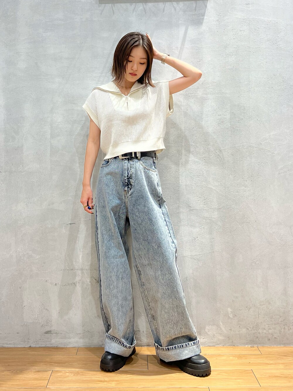 ホワイト系のニット/セーター、ブルー系のデニムパンツ、ブラック系のブーツを着用したレディースの夏コーディネートの5枚目の写真