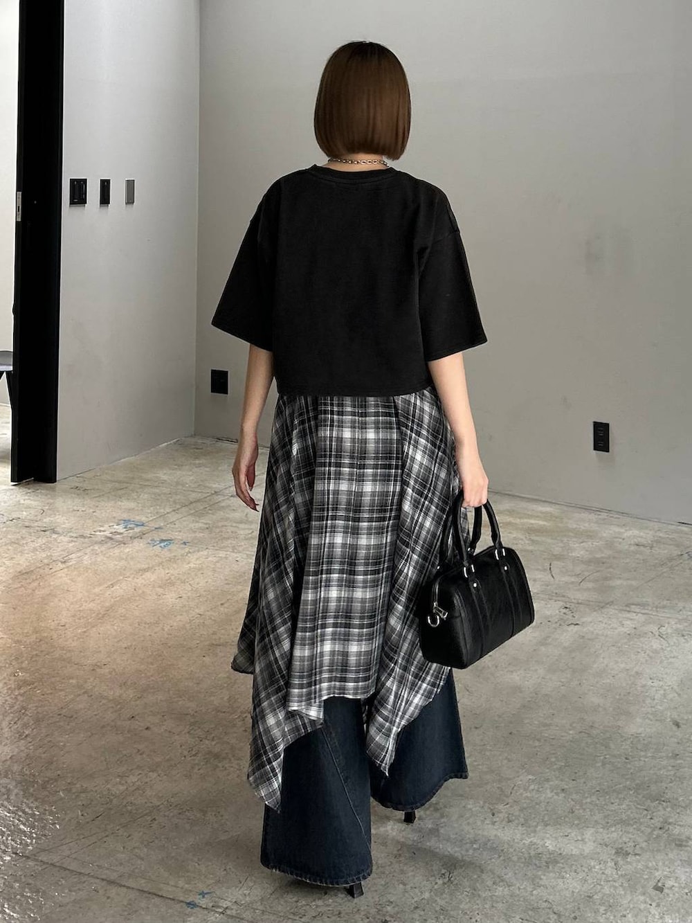 ブルー系のデニムパンツ、ブラック系のボストンバッグ、ブラック系のサンダルを着用したレディースの春コーディネートの3枚目の写真