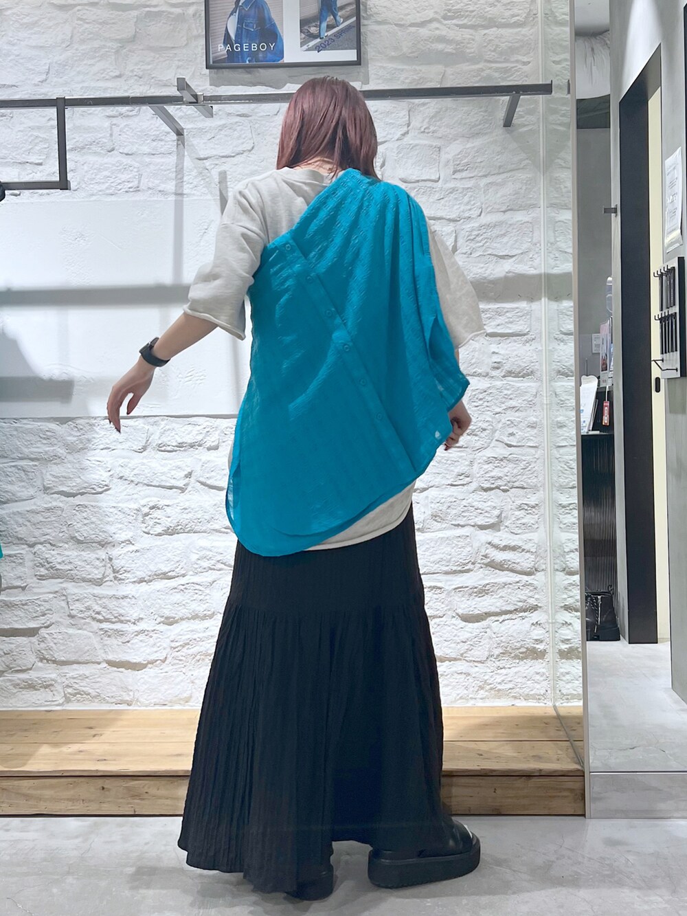 ブラック系のスカート、ベージュ系のTシャツ/カットソーを着用したレディースの春コーディネートの3枚目の写真