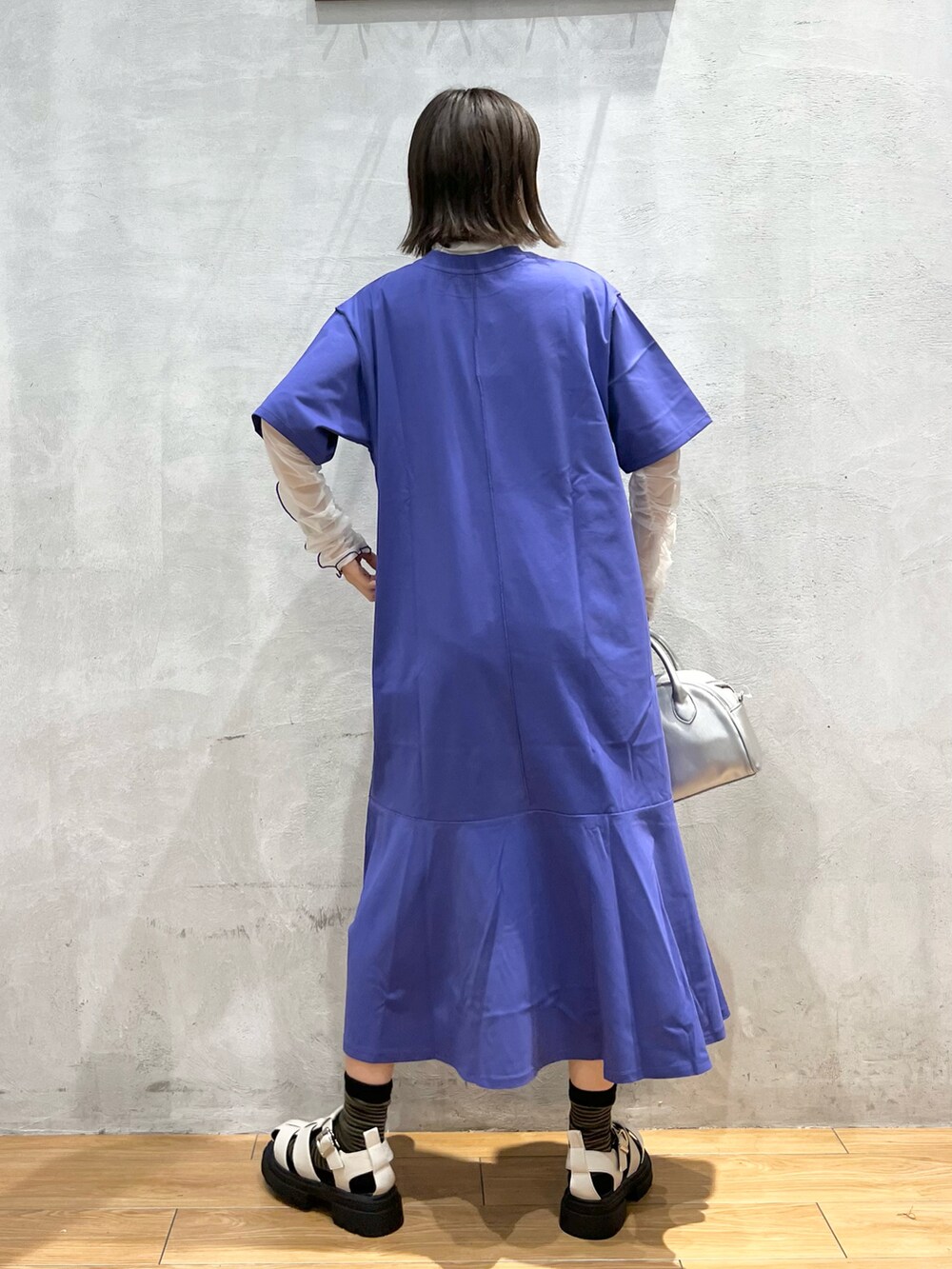 ブルー系のワンピース、ホワイト系のサンダル、シルバー系のショルダーバッグを着用したレディースの夏コーディネートの3枚目の写真