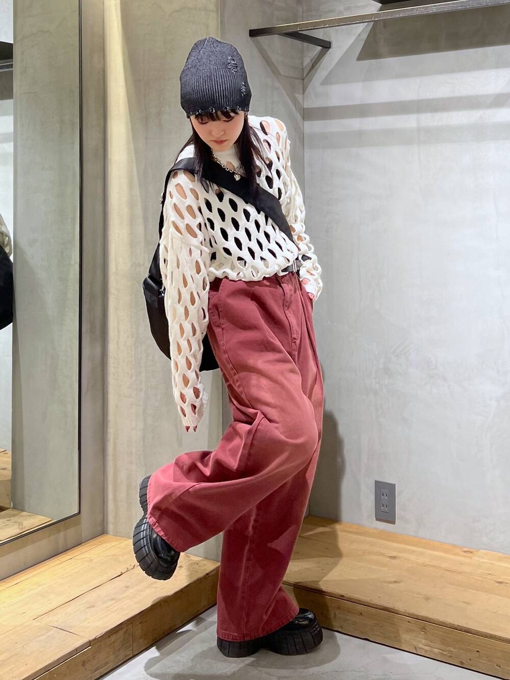 レッド系のデニムパンツ、ブラック系のローファー、ホワイト系のニット/セーターを着用したレディースの冬コーディネートの2枚目の写真