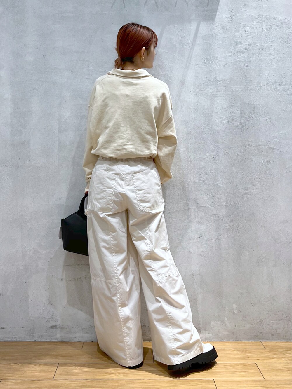 ブラック系のショルダーバッグ、ベージュ系のスウェット、ホワイト系のその他パンツを着用したレディースの冬コーディネートの2枚目の写真