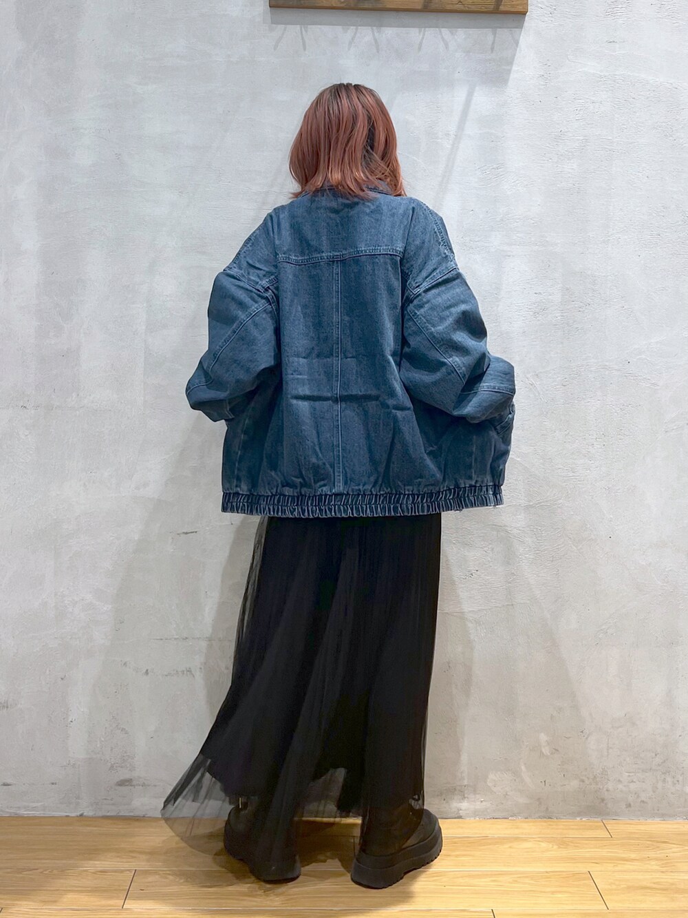 ブラック系のスカート、ブルー系のデニムジャケット、グレー系のTシャツ/カットソーを着用したレディースの春コーディネートの2枚目の写真