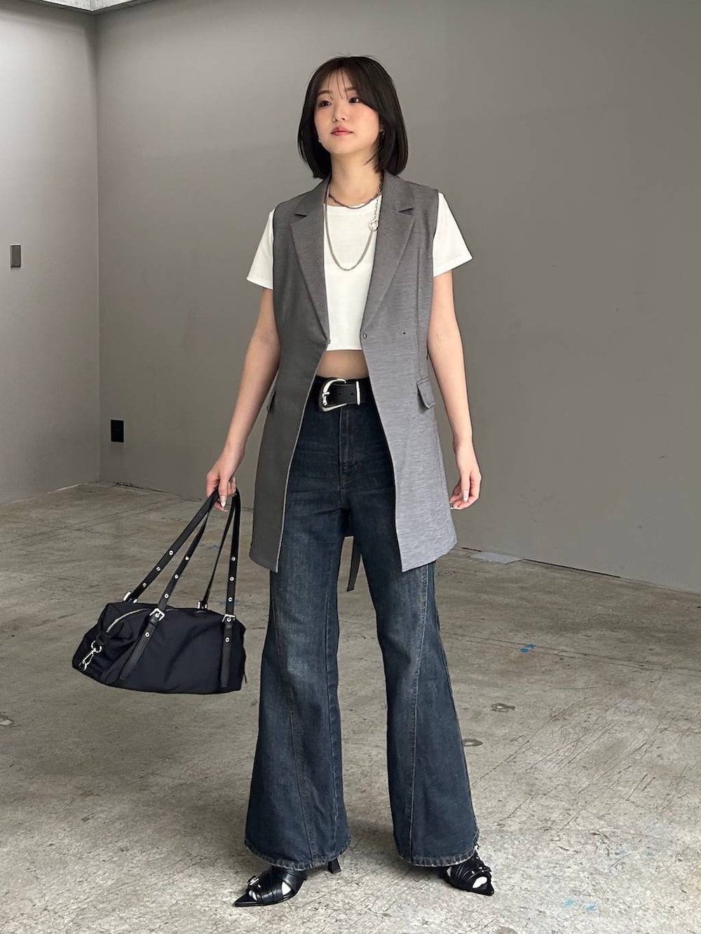 ブルー系のデニムパンツ、ブラック系のサンダル、グレー系のテーラードジャケットを着用したレディースの春コーディネートの4枚目の写真