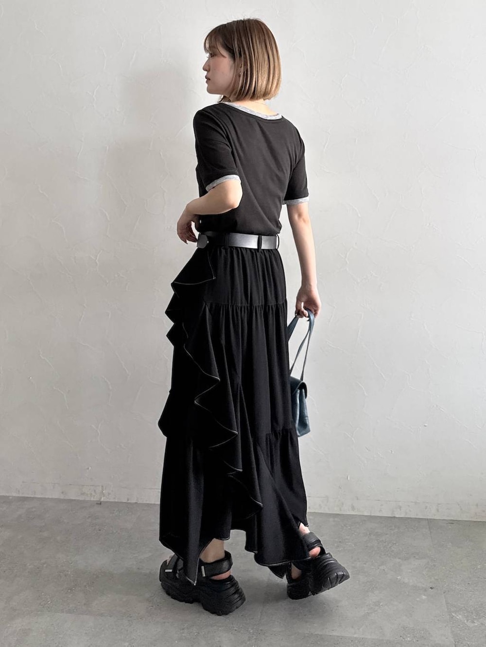 ブラック系のスカート、ブラック系のサンダル、ブラック系のTシャツ/カットソーを着用したレディースの夏コーディネートの4枚目の写真