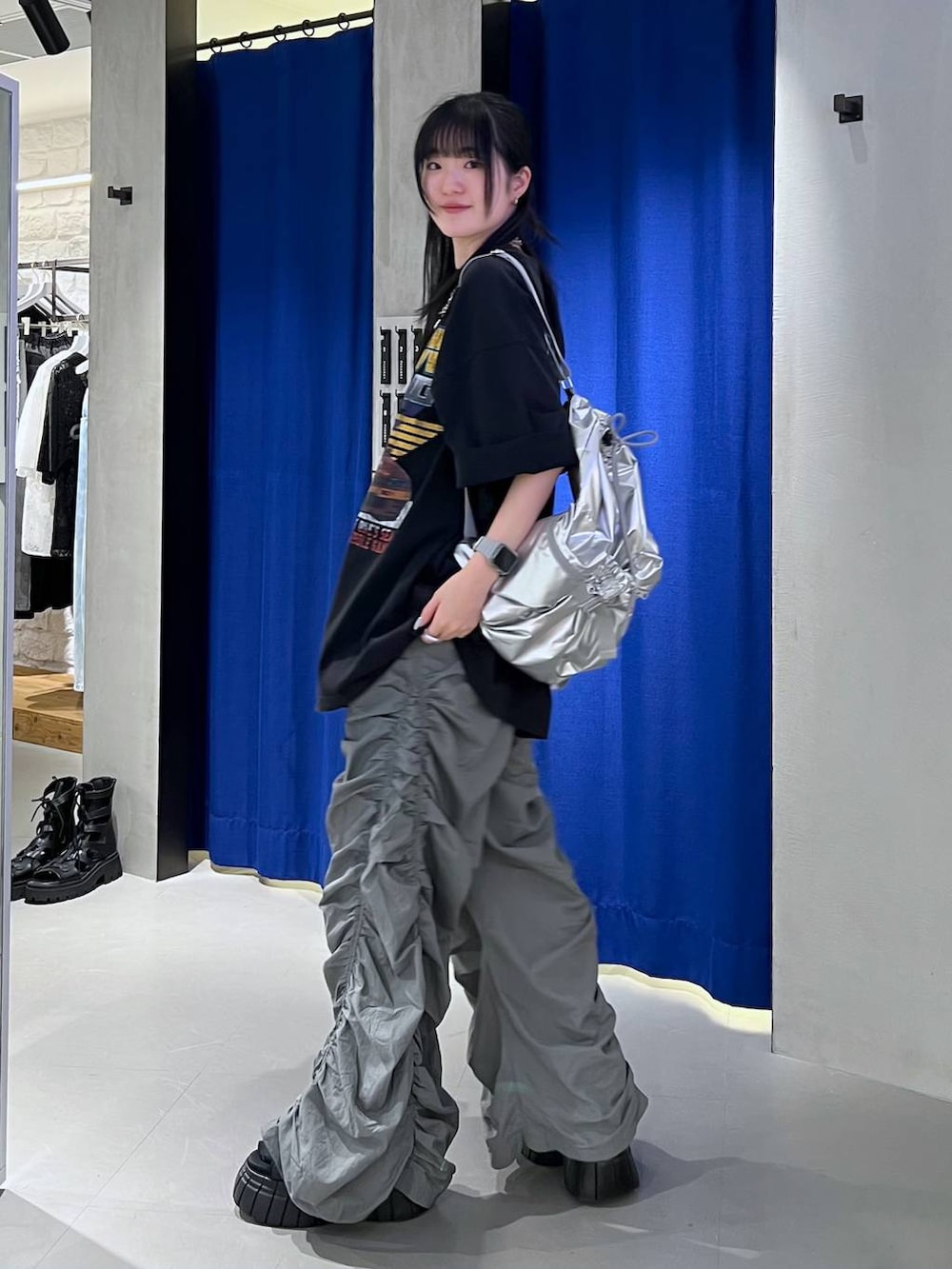 ブラック系のスニーカー、ブラック系のTシャツ/カットソー、シルバー系のショルダーバッグを着用したレディースの春コーディネートの4枚目の写真