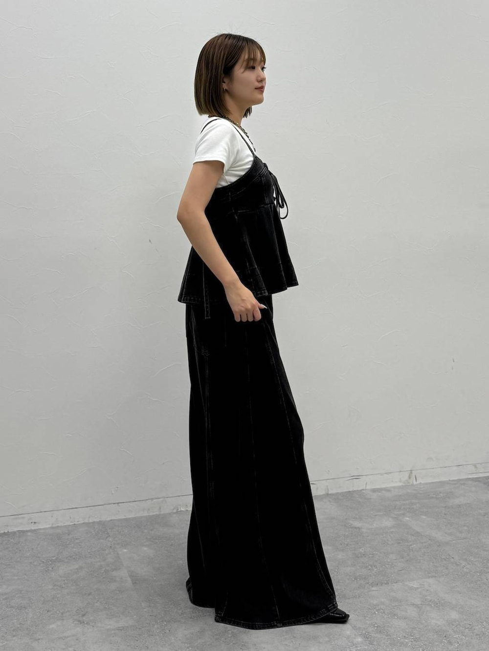 ブラック系のデニムパンツ、ブラック系のその他トップス、ホワイト系のTシャツ/カットソーを着用したレディースの夏コーディネートの6枚目の写真