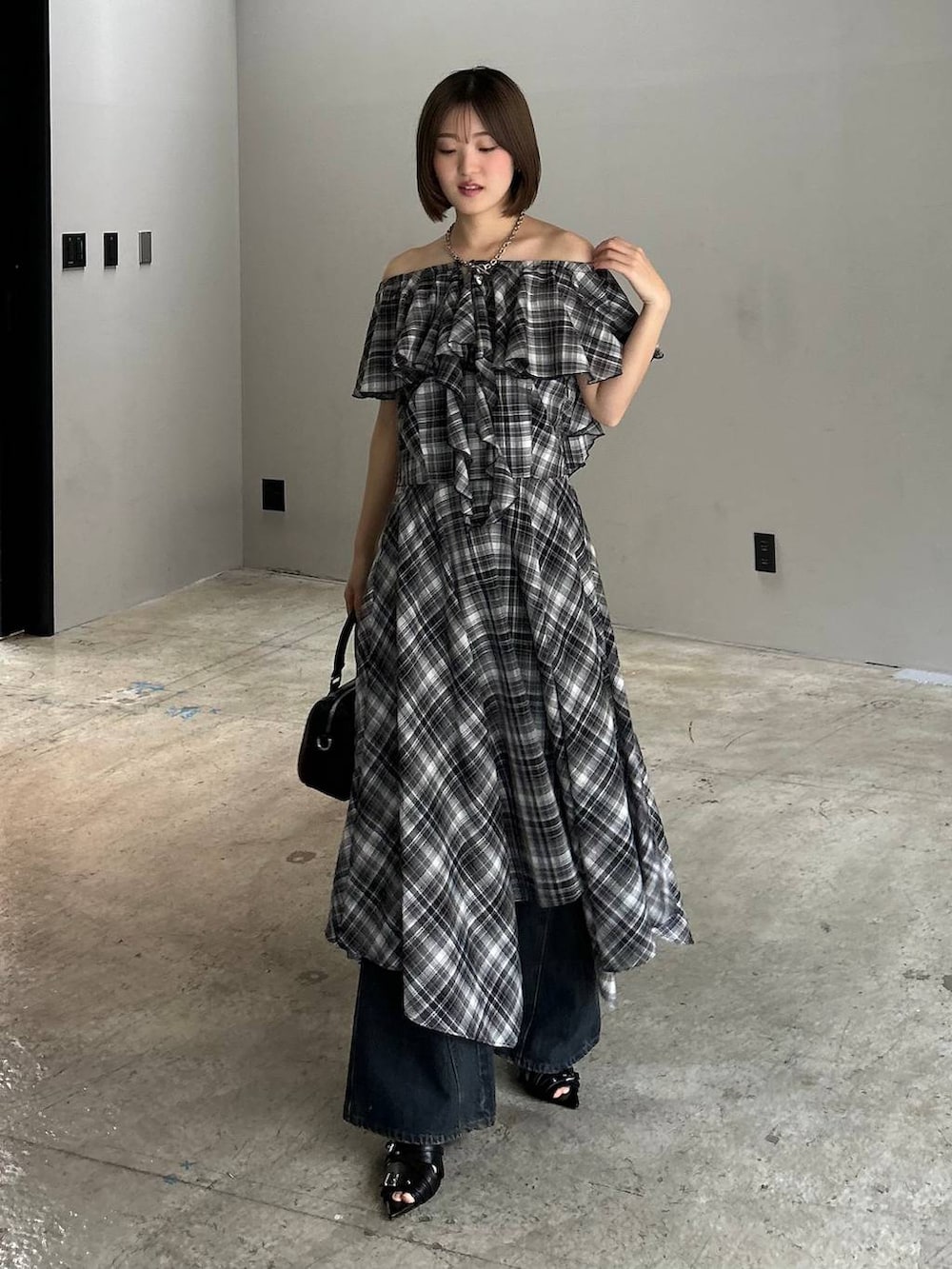 ブルー系のデニムパンツ、ブラック系のボストンバッグ、ブラック系のサンダルを着用したレディースの春コーディネートの5枚目の写真