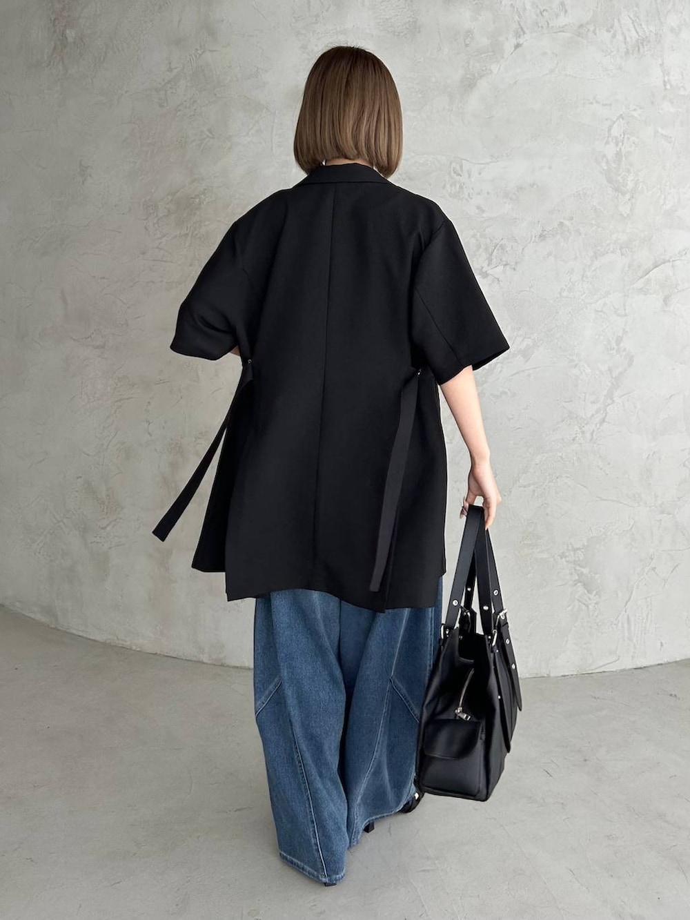 ブラック系のキャミソール、ブルー系のデニムパンツ、ブラック系のサンダルを着用したレディースの春コーディネートの3枚目の写真