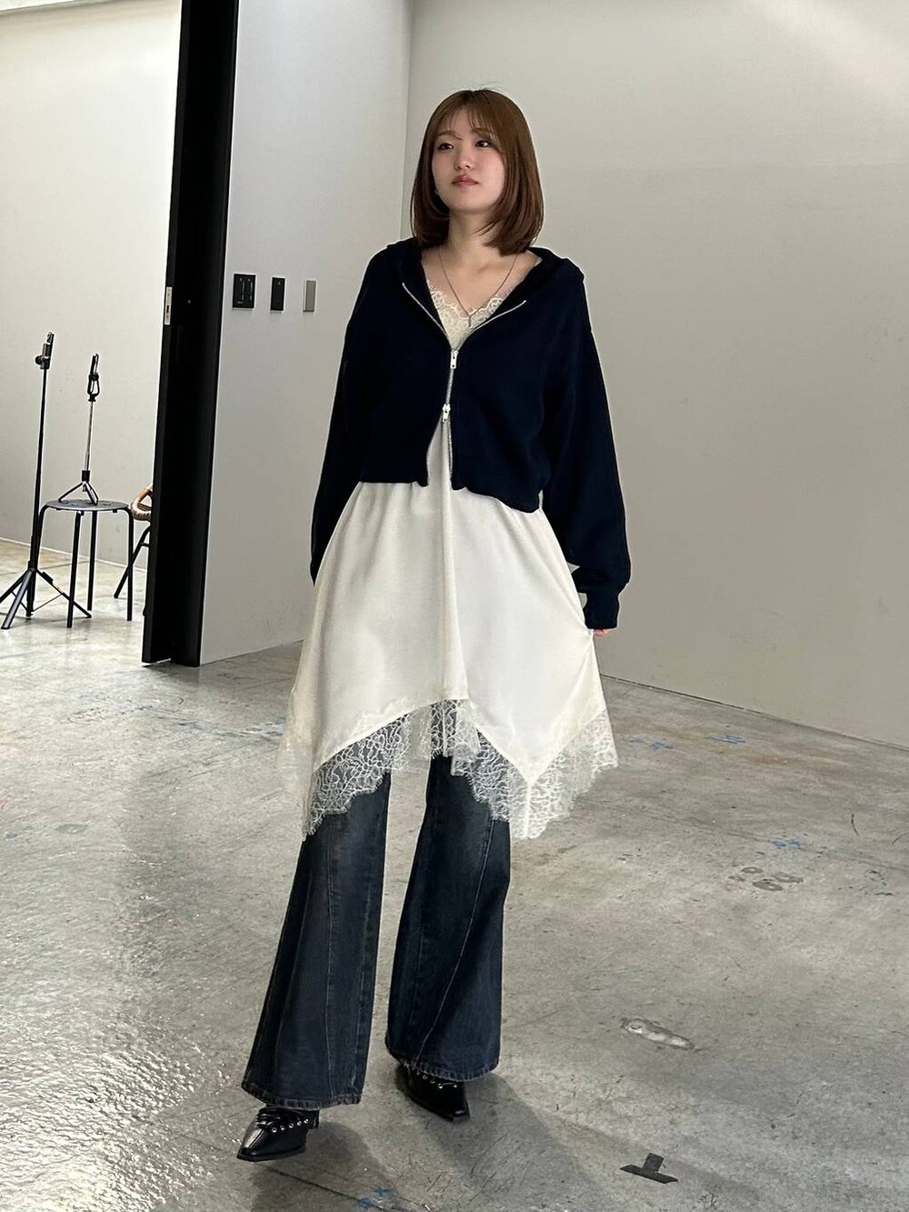ブルー系のデニムパンツ、ブラック系のサンダル、ブルー系のパーカーを着用したレディースの冬コーディネートの5枚目の写真