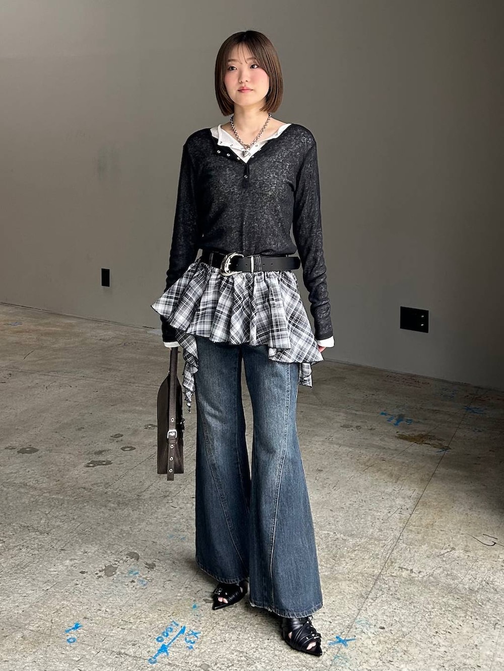 ブルー系のデニムパンツ、ブラウン系のハンドバッグ、ブラック系のTシャツ/カットソーを着用したレディースの春コーディネートの3枚目の写真