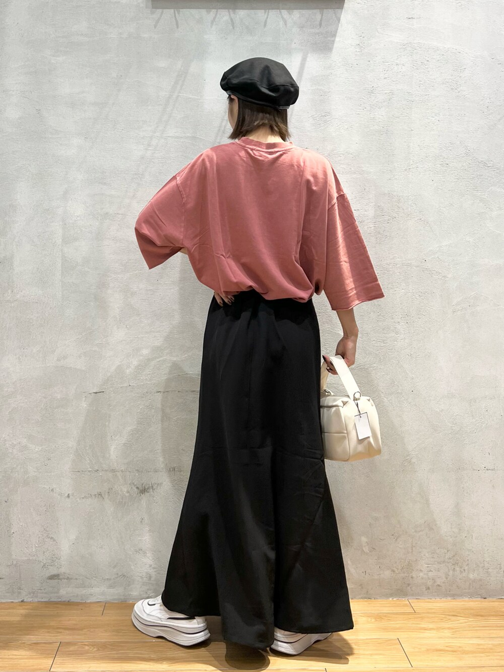 ピンク系のTシャツ/カットソー、ホワイト系のショルダーバッグ、ブラック系のスカートを着用したレディースの秋コーディネートの4枚目の写真