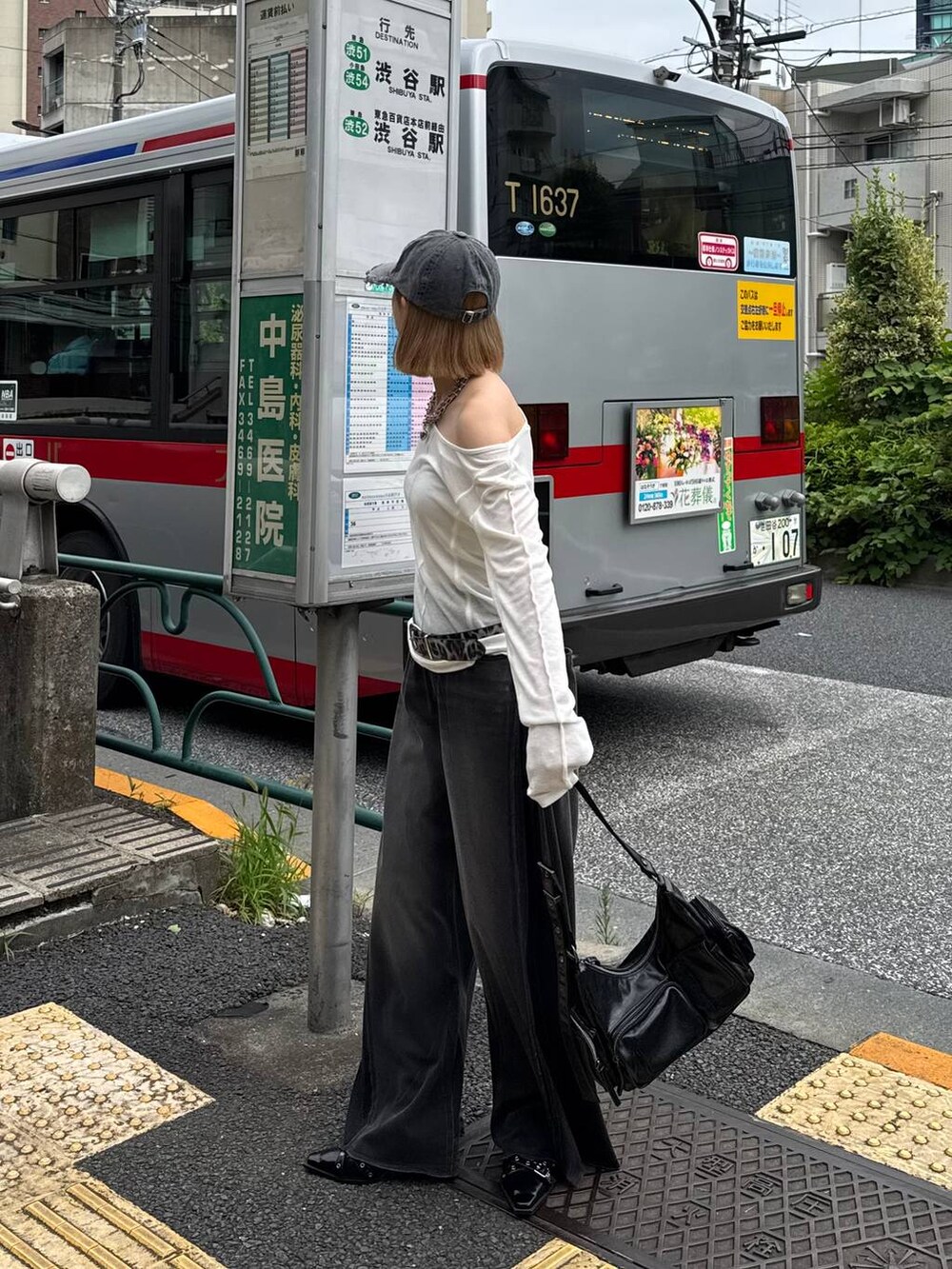 ブラック系のデニムパンツ、ブラック系のショルダーバッグ、ブラック系のキャップを着用したレディースの夏コーディネートの2枚目の写真
