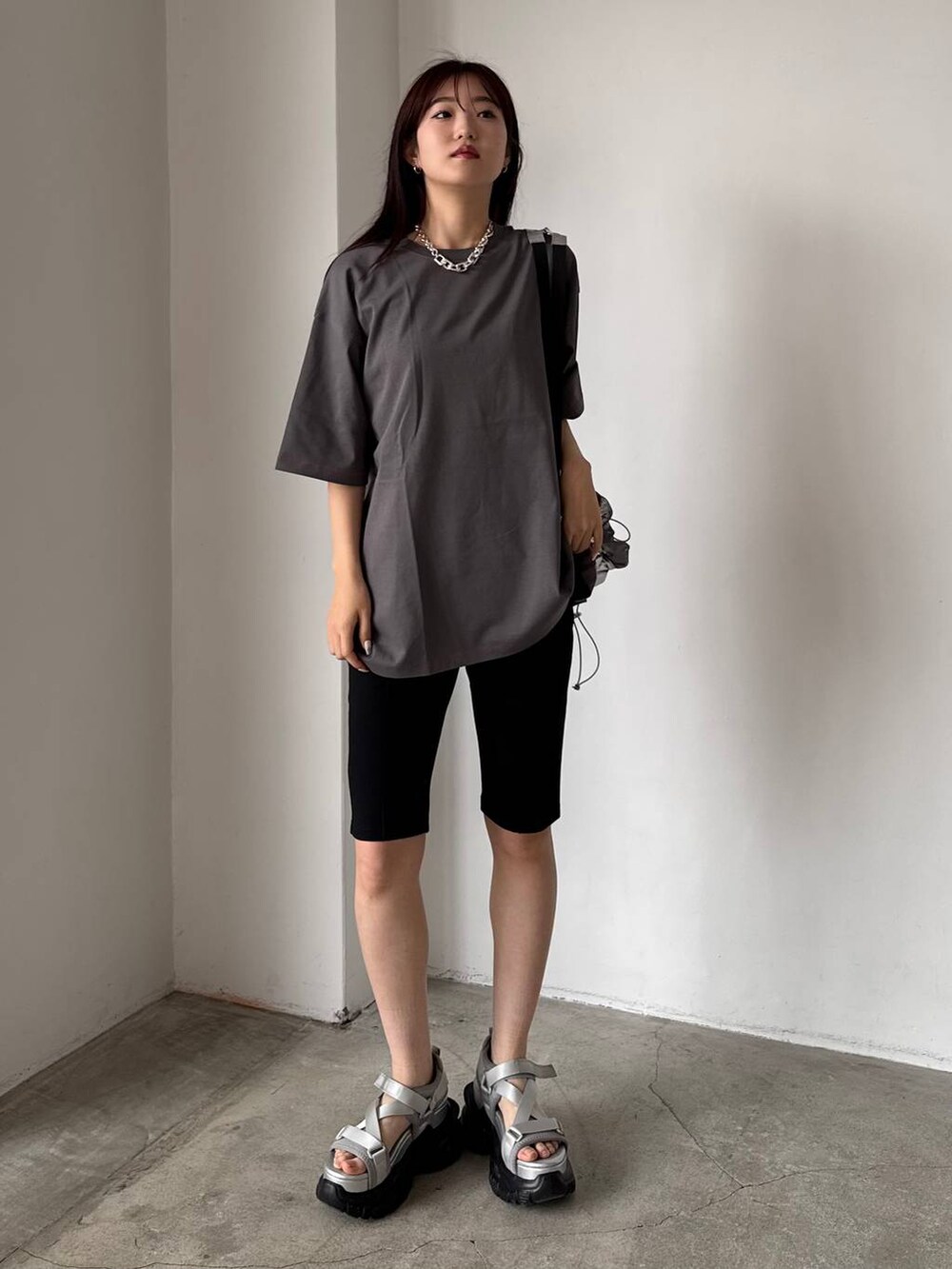 グレー系のサンダル、シルバー系のバックパック/リュック、グレー系のTシャツ/カットソーを着用したレディースの春コーディネートの4枚目の写真