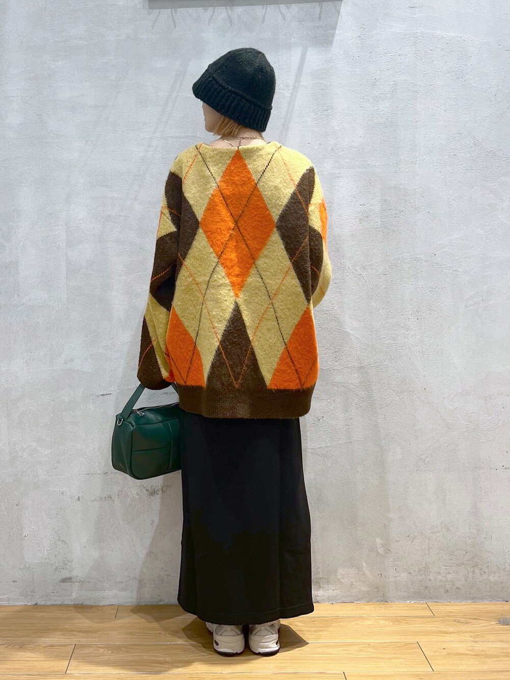 グリーン系のショルダーバッグ、ブラウン系のカーディガン/ボレロ、ブラック系のスカートを着用したレディースの秋コーディネートの3枚目の写真