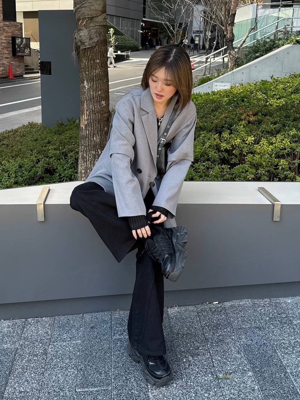 ブラック系のスニーカー、ブラック系のデニムパンツ、ブラック系のハンドバッグを着用したレディースの春コーディネートの4枚目の写真