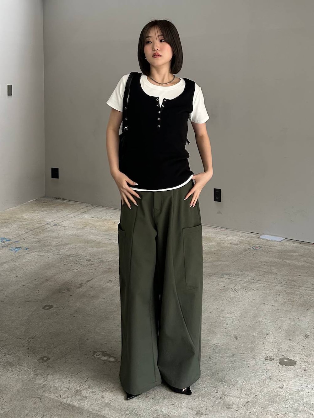 グリーン系のカーゴパンツ、ブラック系のサンダル、ブラック系のボストンバッグを着用したレディースの春コーディネートの3枚目の写真