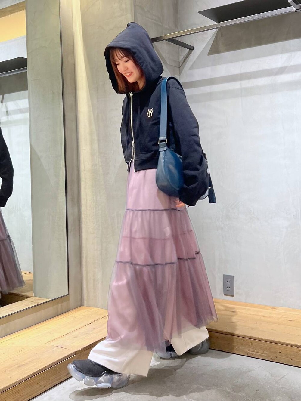 ブラック系のパーカー、ベージュ系のスラックス、グレー系のスカートを着用したレディースの冬コーディネートの3枚目の写真