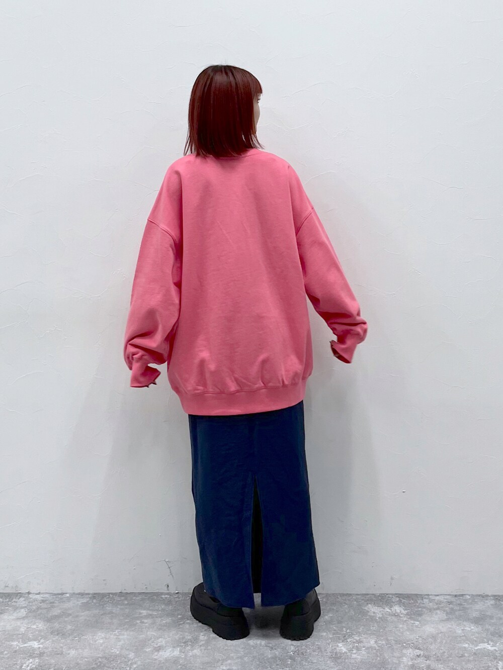 ピンク系のスウェット、ブラック系のブーツを着用したレディースの冬コーディネートの2枚目の写真