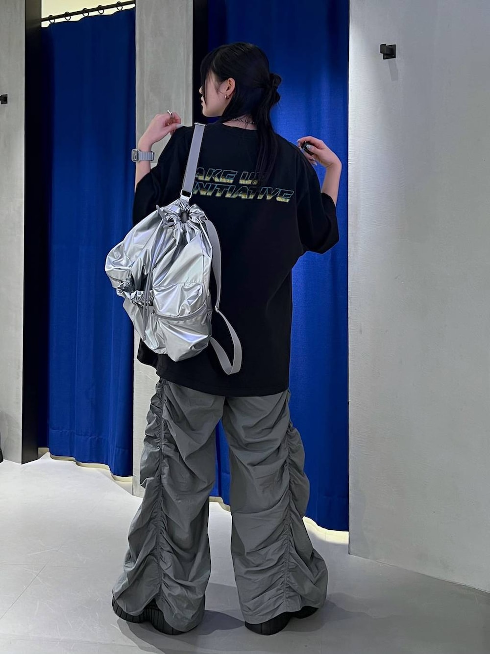 ブラック系のスニーカー、ブラック系のTシャツ/カットソー、シルバー系のショルダーバッグを着用したレディースの春コーディネートの3枚目の写真