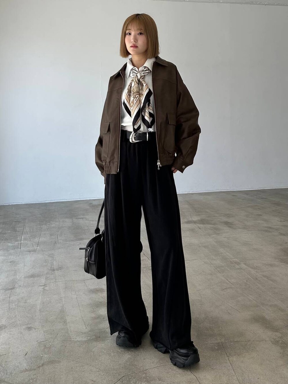 ブラック系のブーツ、ブラック系のスウェットパンツ、ブラック系のボストンバッグを着用したレディースの秋コーディネートの2枚目の写真