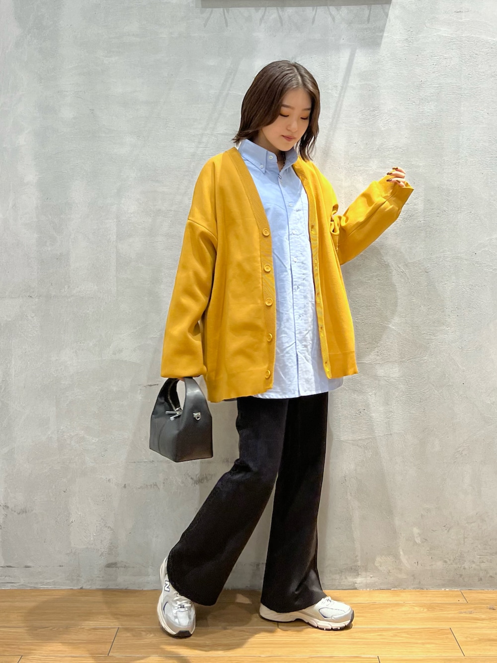 ブラック系のスラックス、ブラック系のショルダーバッグ、グレー系のスニーカーを着用したレディースの秋コーディネートの2枚目の写真