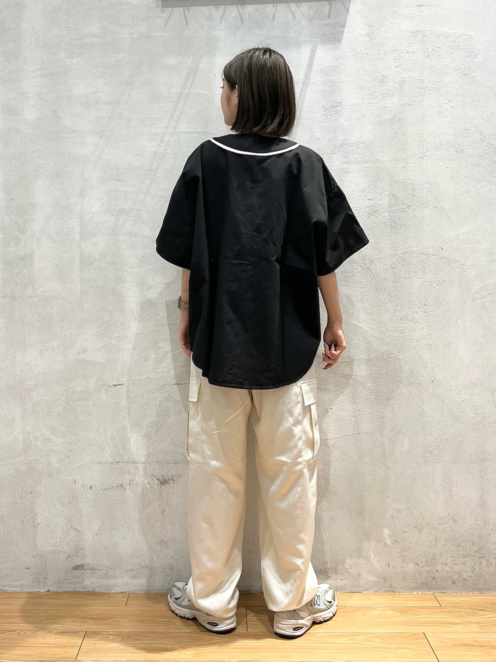 ホワイト系のパンツ、グレー系のスニーカー、ブラック系のシャツ/ブラウスを着用したレディースの夏コーディネートの3枚目の写真