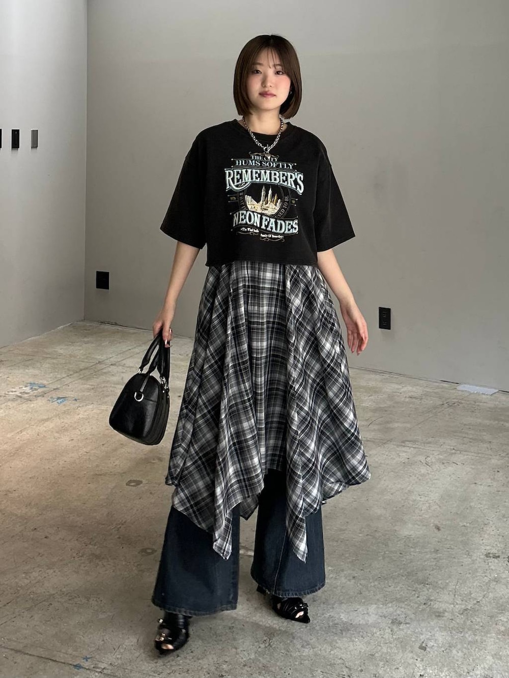 ブルー系のデニムパンツ、ブラック系のボストンバッグ、ブラック系のサンダルを着用したレディースの春コーディネートの2枚目の写真