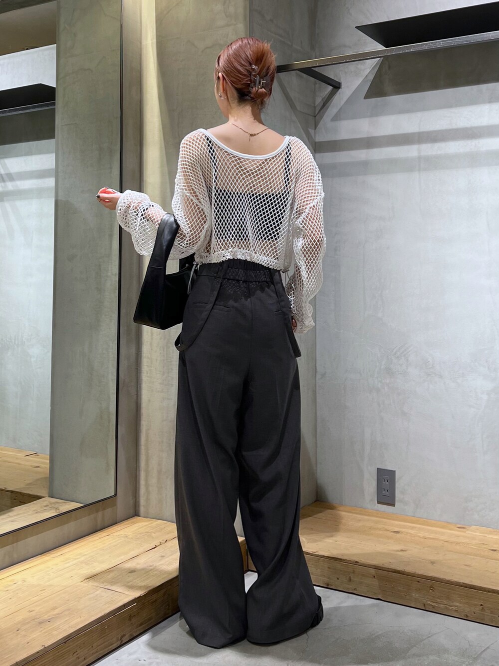 グレー系のスラックス、ホワイト系のTシャツ/カットソー、ブラック系のハンドバッグを着用したレディースの夏コーディネートの2枚目の写真