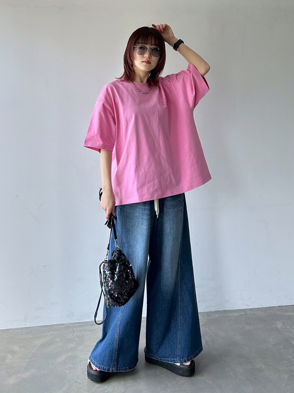 ピンク系のTシャツ/カットソー、ブルー系のデニムパンツ、ブラック系のショルダーバッグを着用したレディースの春コーディネートの4枚目の写真