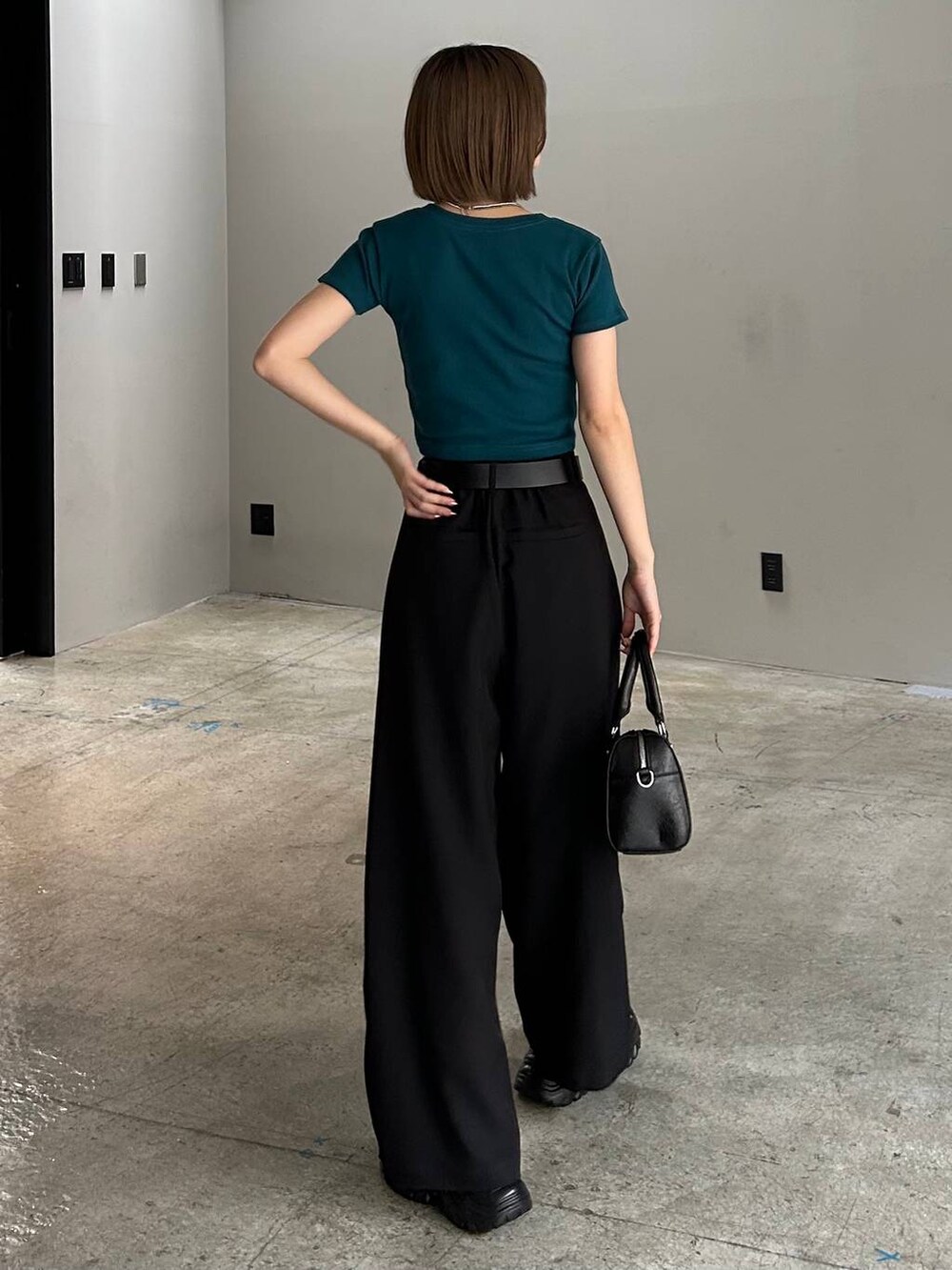 ブラック系のボストンバッグ、ブラック系のサンダル、ブラック系のスラックスを着用したレディースの春コーディネートの3枚目の写真